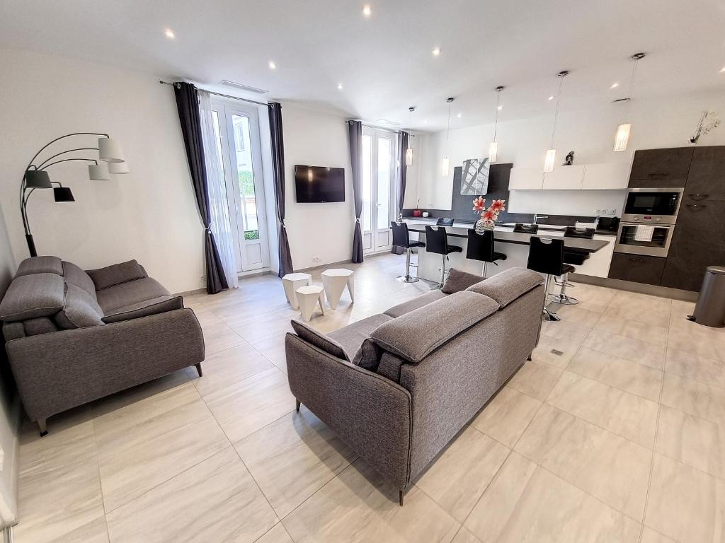 カンヌにあるAppartement Cannes Centreのソファ2台付きの広いリビングルーム、キッチンが備わります。