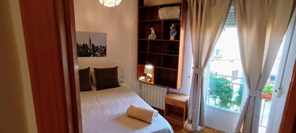 - une chambre avec un lit et une grande fenêtre dans l'établissement Habitación CDV, à Madrid