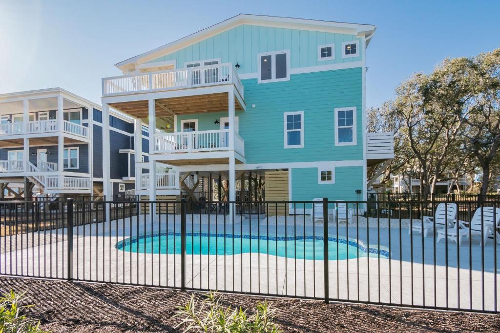 uma casa azul com uma piscina em frente em Oki Dokey by Oak Island Accommodations em Oak Island