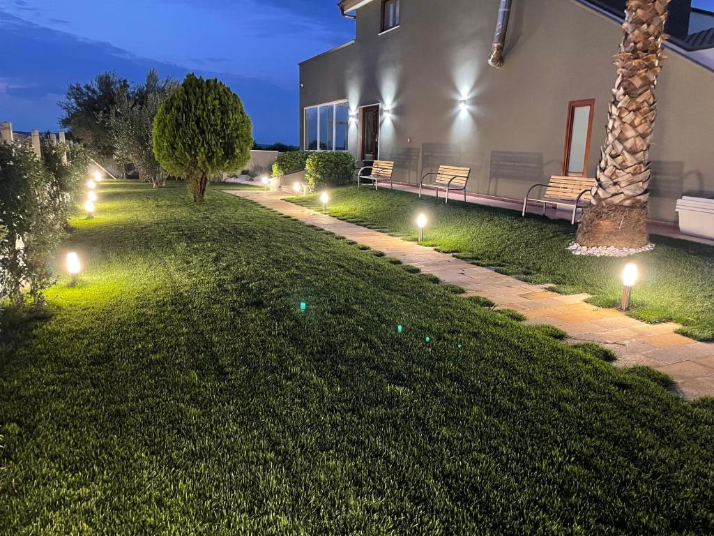 un giardino con luci sul prato di notte di Crival club & more a Palagiano