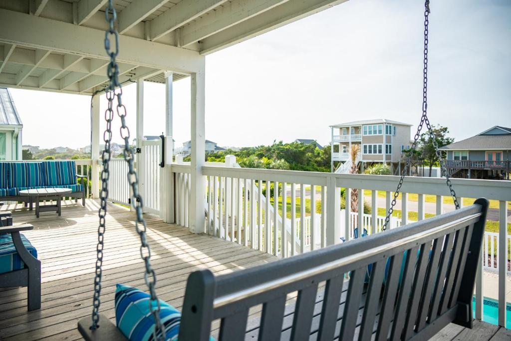 a porch with a swing on a house at A Sea View Cottage by Oak Island Accommodations in Oak Island