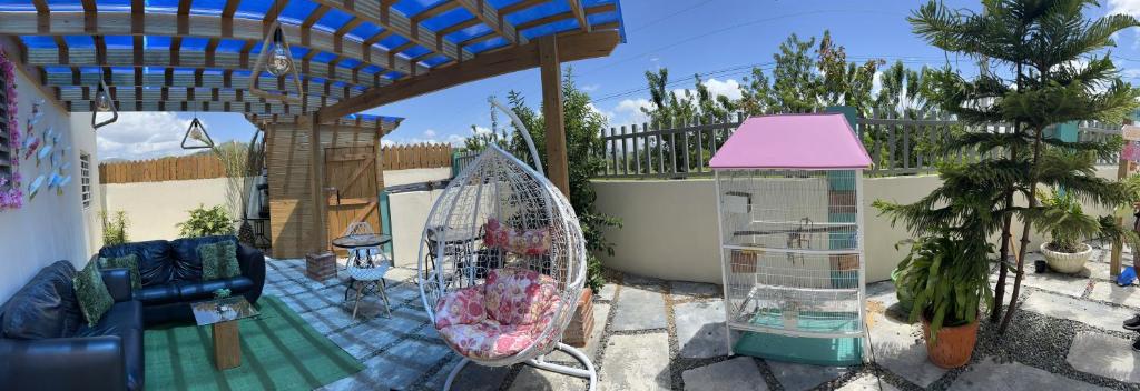 un patio con una jaula para aves y una casa en A-3 apartamentos al pie de la montaña con piscina, en Jarabacoa