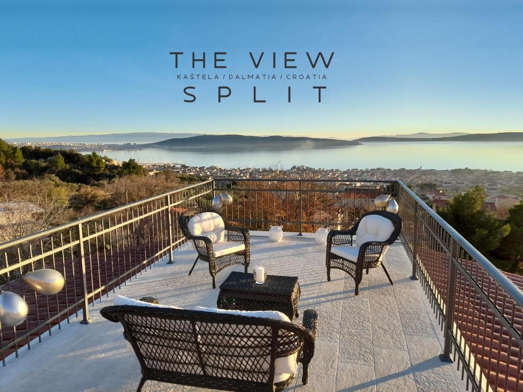 uma varanda com cadeiras e vista para a água em The View Split. Highlight with Roof-Top-Terrace and Pool em Kaštela