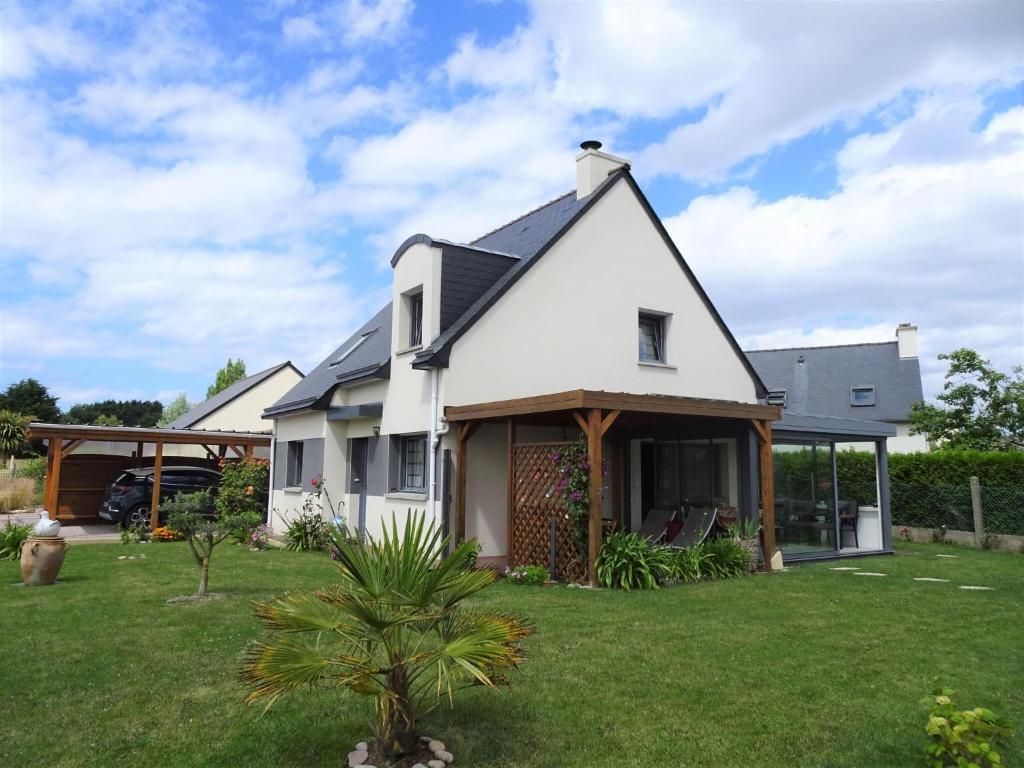 une maison blanche avec une cour verdoyante dans l'établissement Holiday home, Frehel, à Fréhel