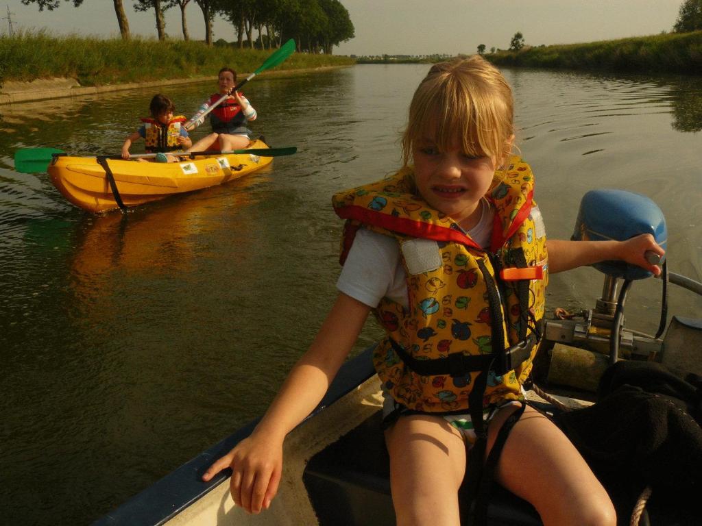 Una bambina seduta sul retro di una barca di De Boot a Merkem