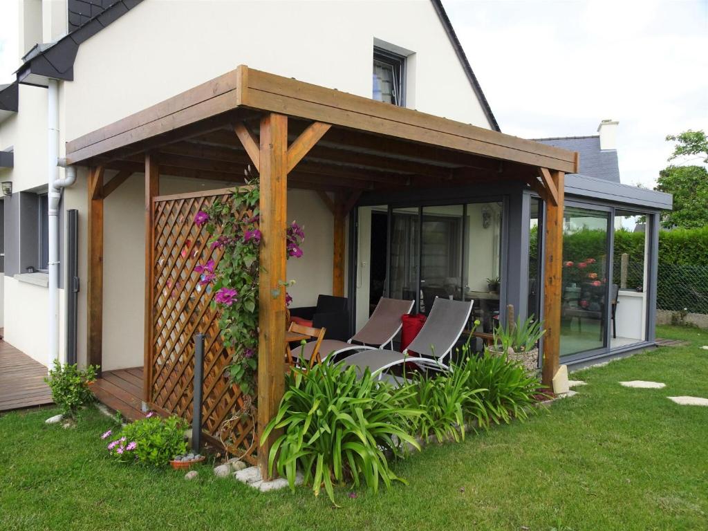 una pérgola con sillas y una mesa en Chalet near Cap Frehel with Coastal Views, en Fréhel