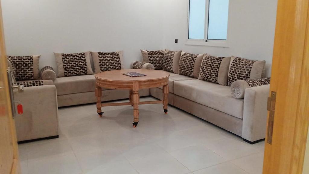 un soggiorno con divano e tavolo di Superbe Appartement ad Al-Ḥoseyma