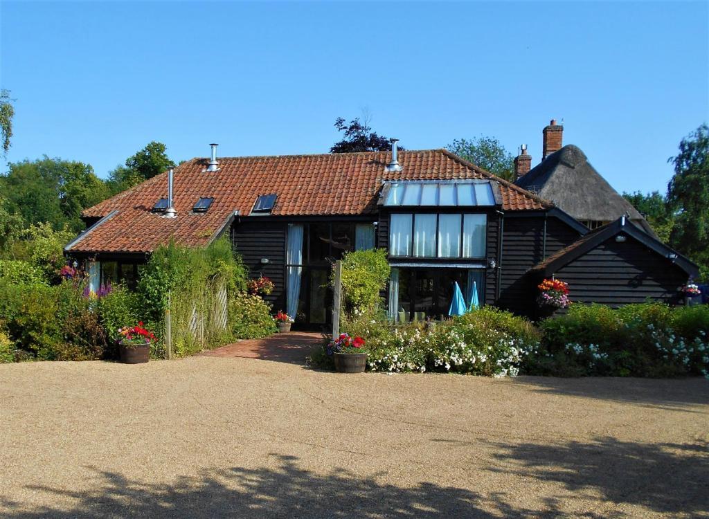 dom z dachem z kwiatami na dziedzińcu w obiekcie Brundish Suffolk Large 4-Bed Barn Stunning! w mieście Woodbridge