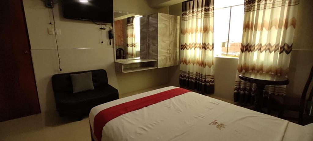1 dormitorio con 1 cama, 1 silla y 1 ventana en Hotel Real Bolivar, en Chimbote