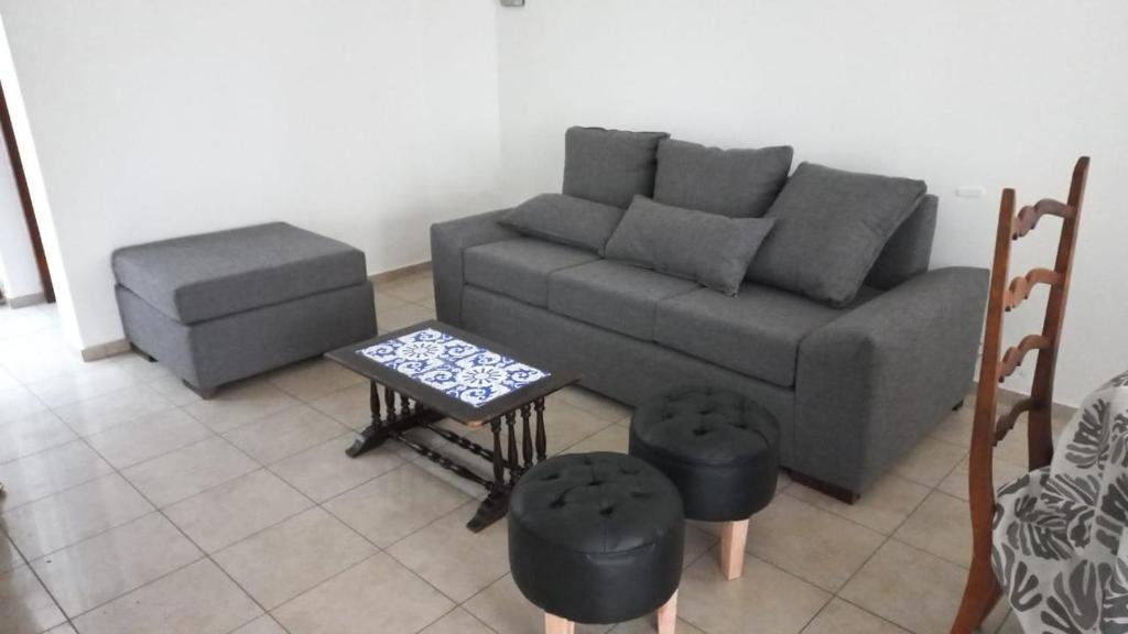 a living room with a couch and a stool at Departamento Quinta Sección in Mendoza