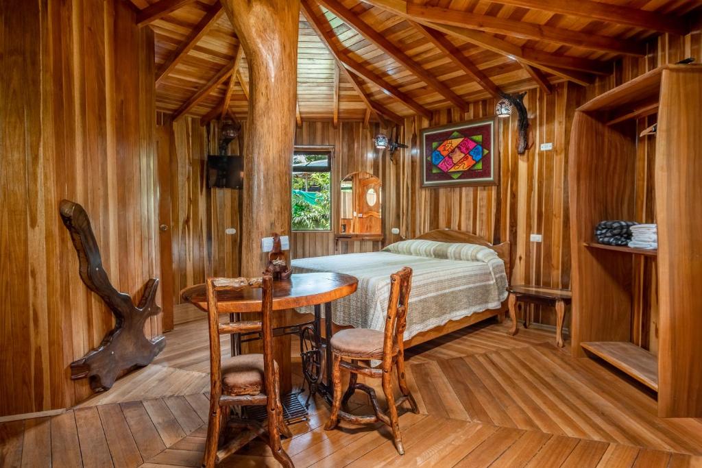 Schlafzimmer mit einem Bett, einem Tisch und Stühlen in der Unterkunft Casitas del Bosque Monteverde. in Monteverde Costa Rica