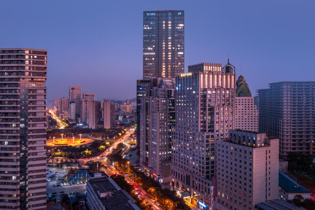 Wuhan Hongguang Hotel في ووهان: اطلالة ليلية على مدينة ذات مباني طويلة