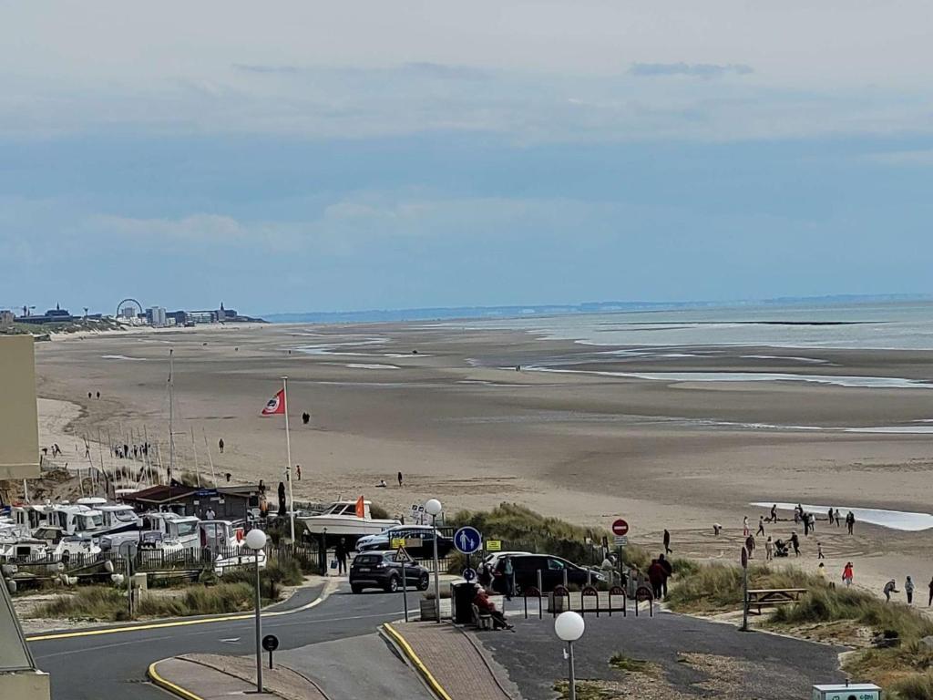 - une vue sur une plage avec des voitures garées sur une route dans l'établissement Magnifique Appartement Face Mer avec 2 Balcons, Terrasse et Ascenseur - FR-1-672-4, à Merlimont