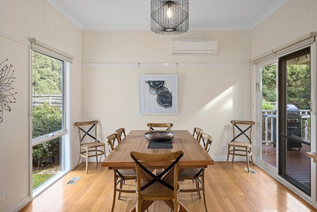 a dining room with a wooden table and chairs at Yarra Gables in Healesville
