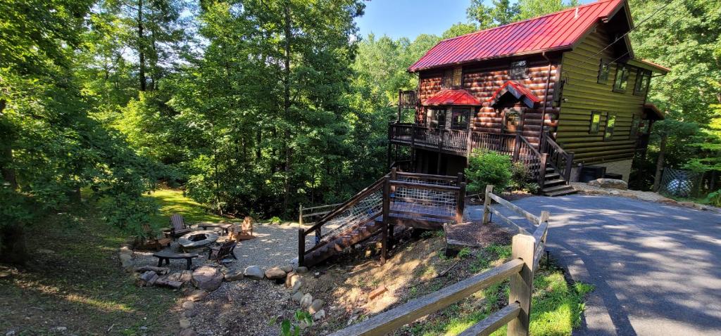 a log cabin in the woods with a red roof at S'more Fun in Sevierville