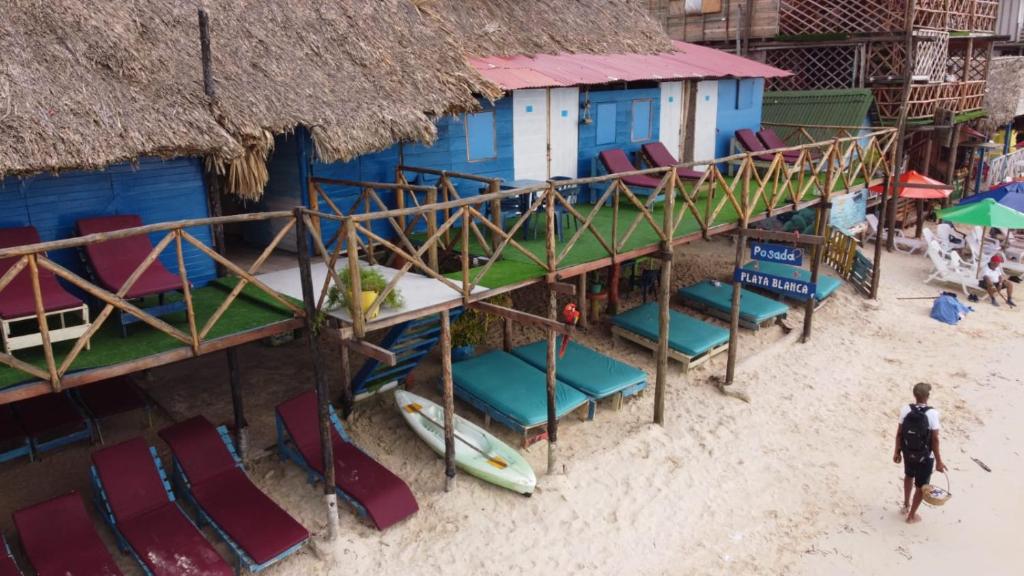 プラヤ・ブランカにあるHostal Playa Blancaのビーチの景色を望む椅子と建物