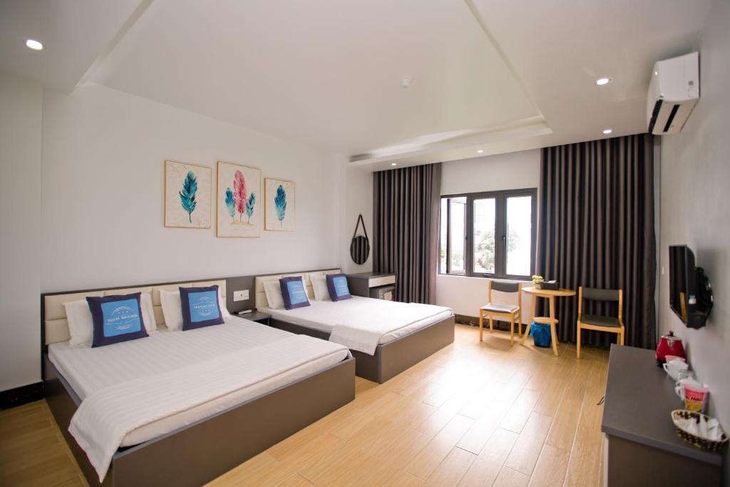 una camera d'albergo con due letti e una televisione di King House Hotel a Móng Cái