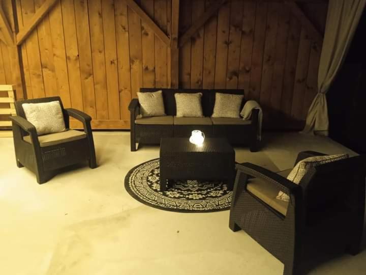 sala de estar con 2 sillas, sofá y mesa en Kiscsermely Vendégház, en Jósvafő