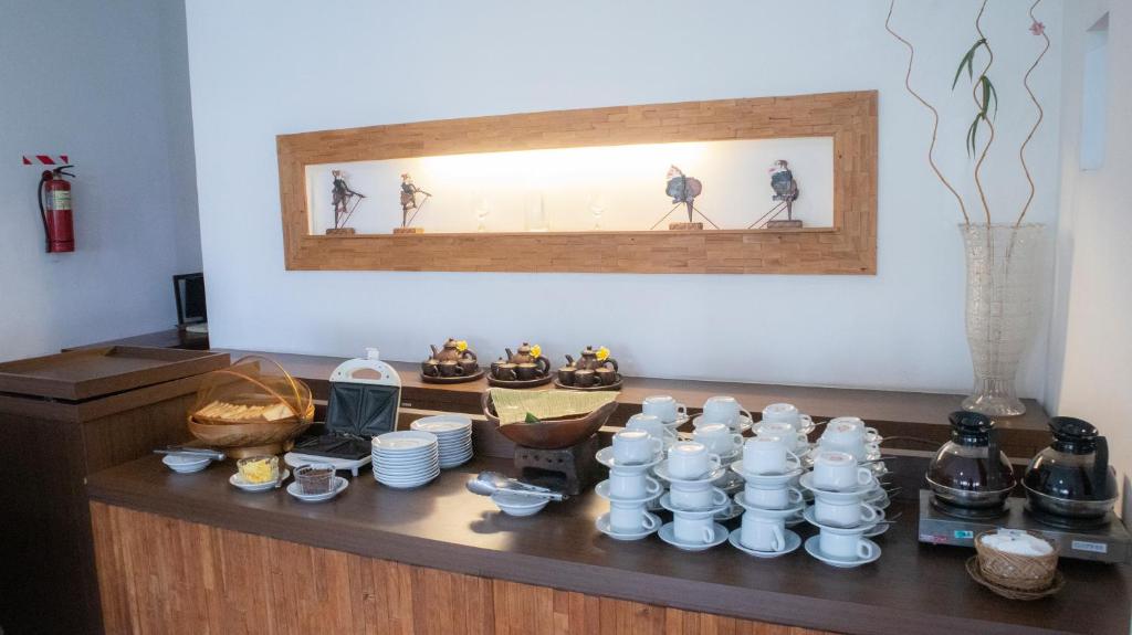 un tavolo con tazze e piatti sopra di Mawar Asri Hotel a Yogyakarta