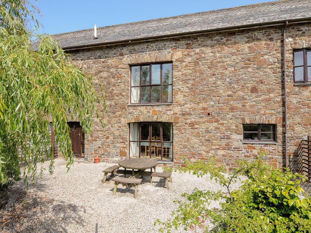 a picnic table in front of a brick building at The Shippon in Bude