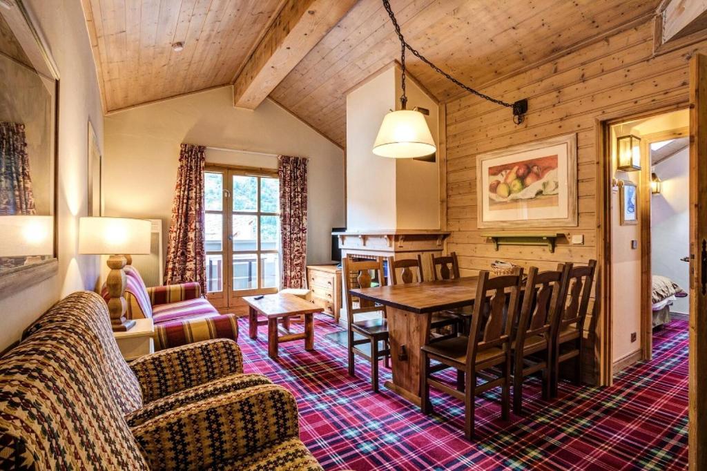 un salon avec une table et des chaises dans une pièce dans l'établissement Résidence Les Arcs 1950 Le Village - maeva Home - Appartement 3 Pièces 6 personnes Sélection MAE-0438, à Bourg-Saint-Maurice