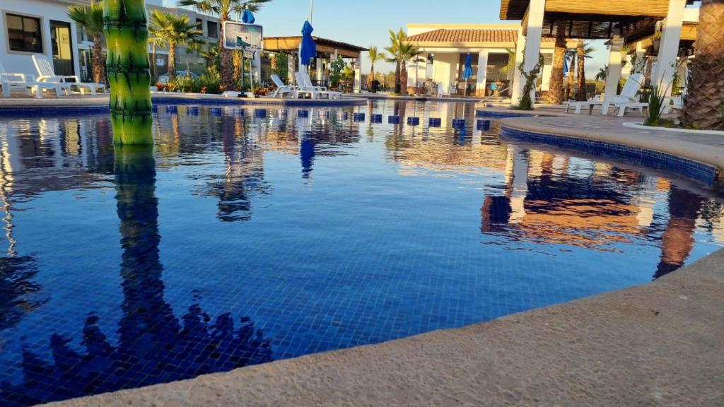 una piscina de agua con palmeras y edificios en Hermoso Departamento nuevo con acceso a Alberca, en Mazatlán