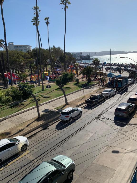 a group of cars driving down a street with palm trees at Hotel Marina Azul in Viña del Mar