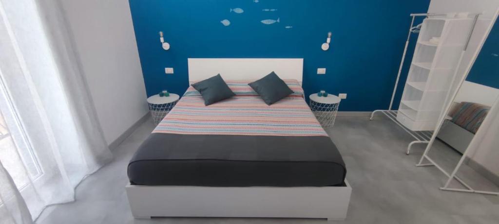 ein Schlafzimmer mit einem großen Bett mit blauen Wänden in der Unterkunft Casa Conchiglia in Lido Conchiglia