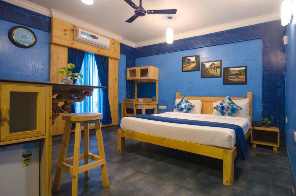 a bedroom with a bed and a blue wall at Liwa Habitat in Bangalore