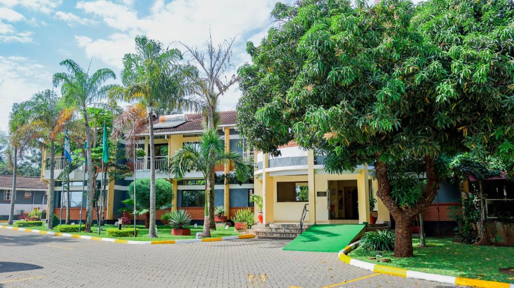 Millsview Hotels in Kisumu في كيزيمو: مبنى فيه اشجار امام شارع