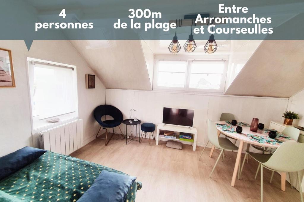 a bedroom with a bed and a table and a tv at Appt cosy - 300m plage-proche Arromanches et Bayeux in Asnelles