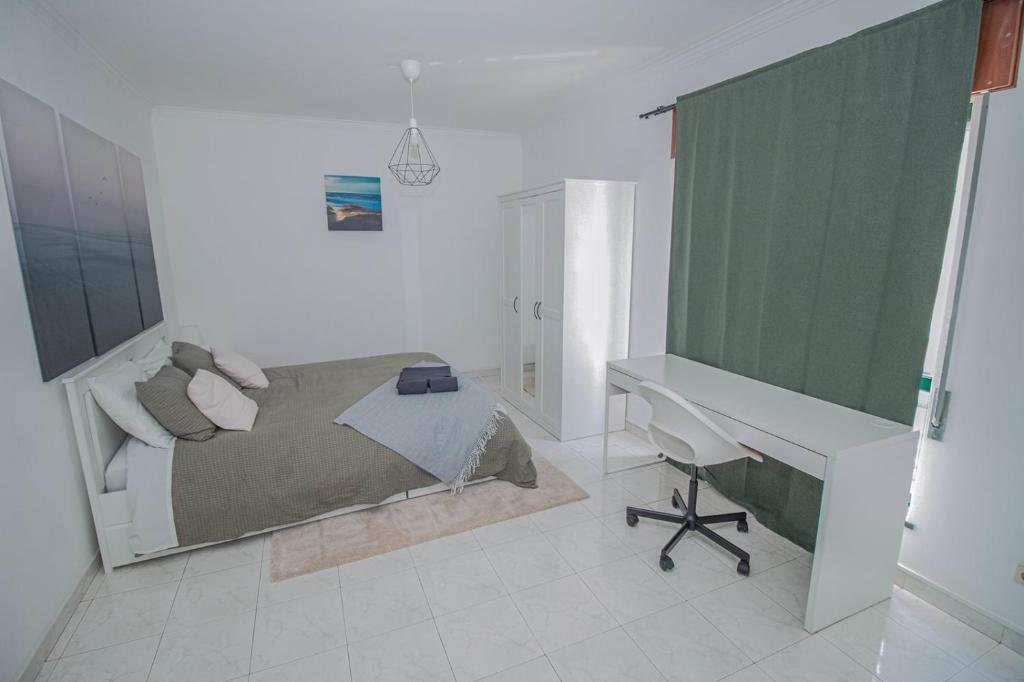 ファロにあるCharming Private Rooms in an Apartment A1 Penha - Faroのベッドルーム1室(ベッド1台、デスク、デスク付)