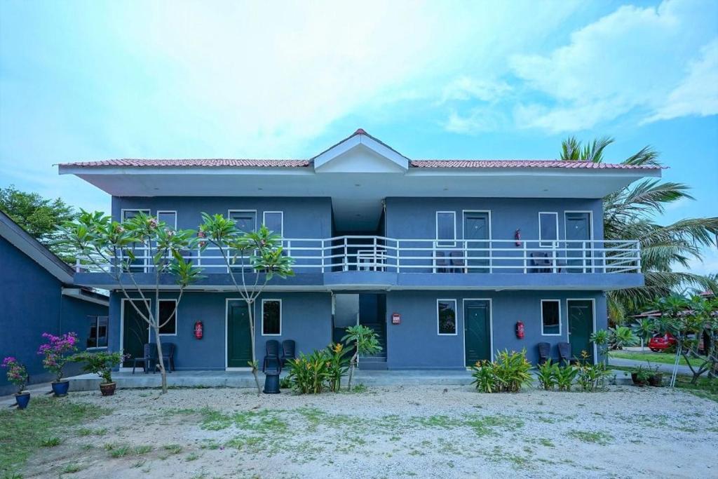a blue house with a balcony on a beach at Mila Motel 2 in Pantai Cenang
