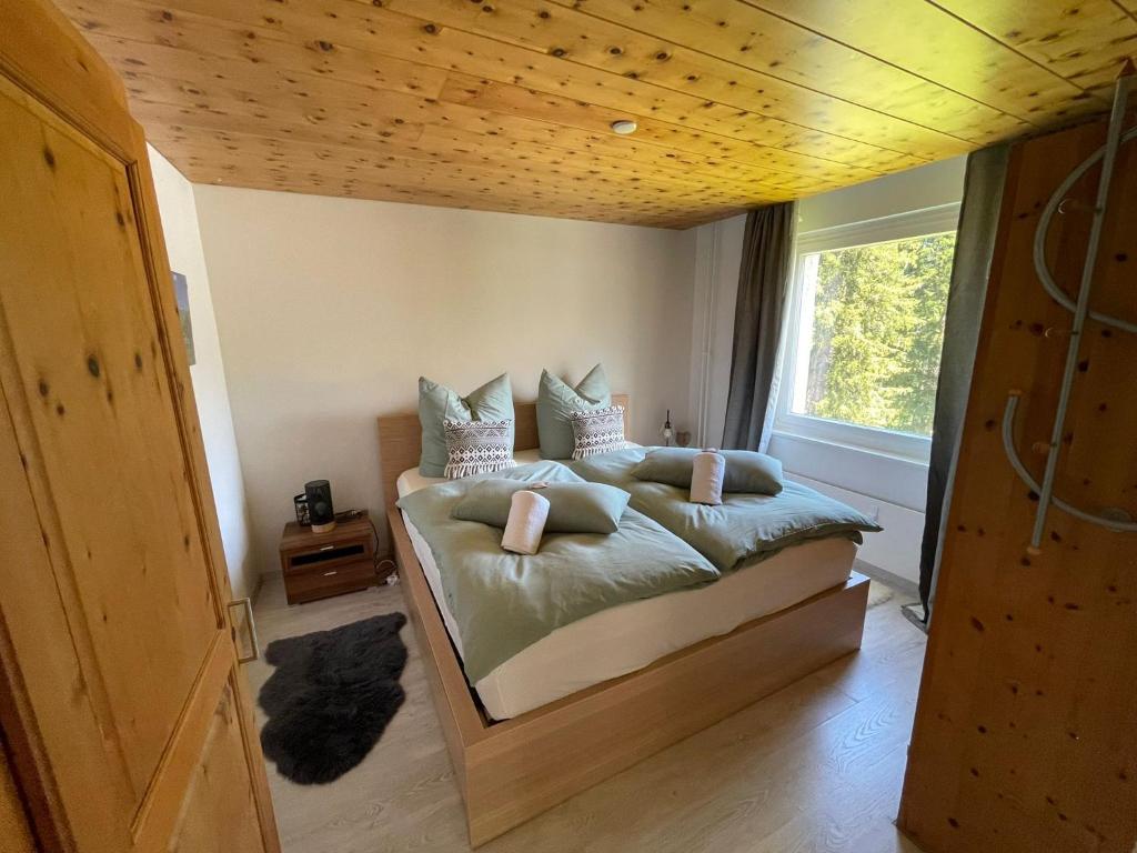 a bedroom with a large bed with a wooden ceiling at Casa Alexandra in Arosa
