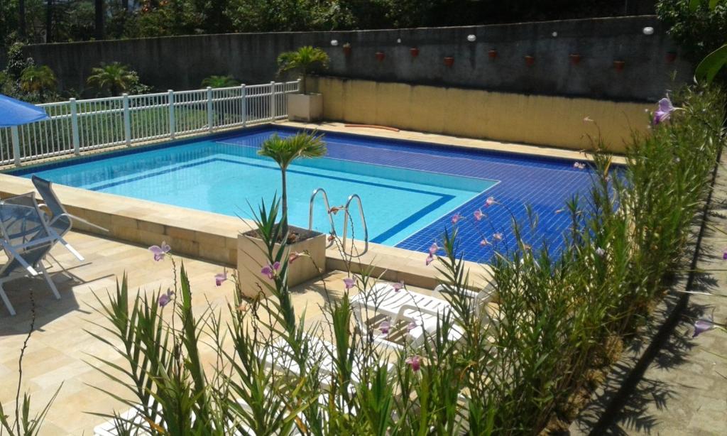 a swimming pool in a yard with a fence at Pousada Matitaterê in Teresópolis