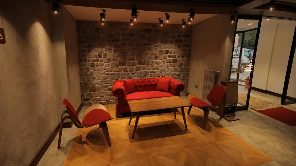 a living room with a red couch and chairs at Abant Kosk Oteli in Abant