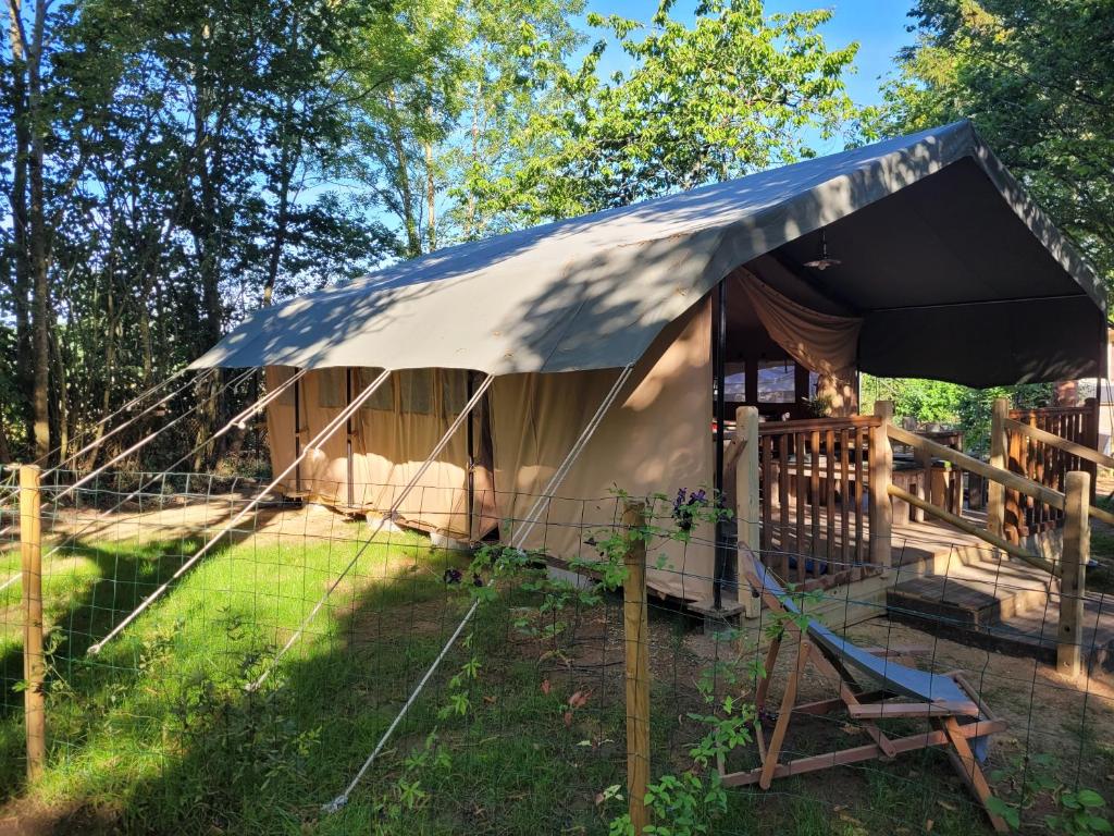 namiot z krzesłem i ogrodzeniem w obiekcie Tente Lodge Safari w mieście Saint-Martin-des-Besaces