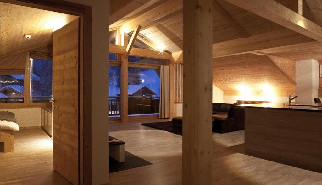 a large living room with wooden walls and ceilings at Helvetia hotel in Morgins