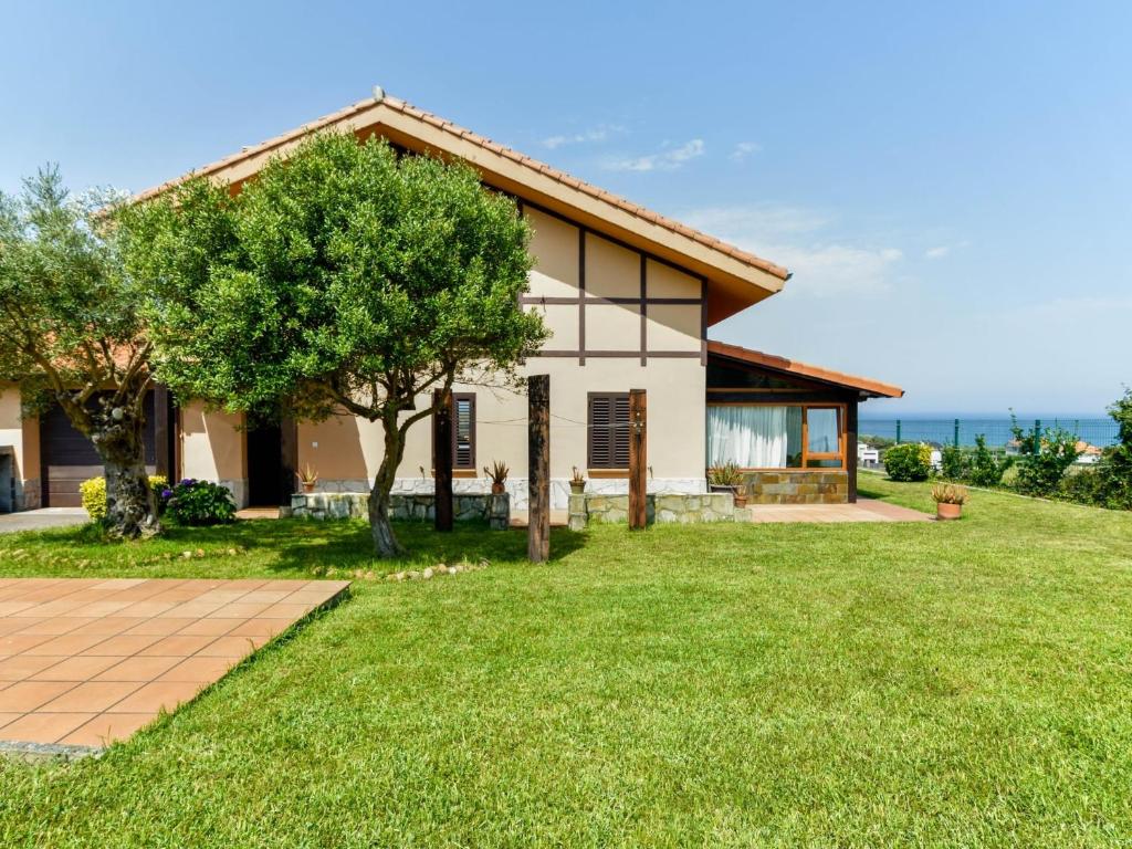a house with a green lawn in front of it at Encantadora casa con espectaculares vistas in Ajo
