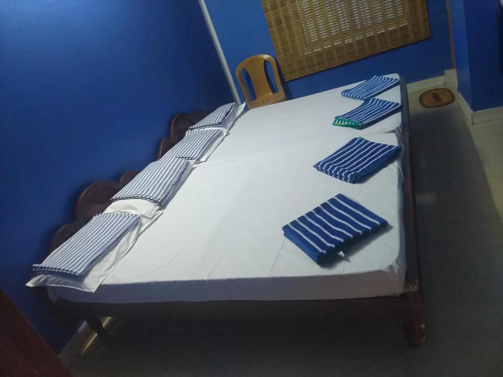 un finto letto d'ospedale con lenzuola blu e bianche di New City Tower Residency a Tiruchchendūr