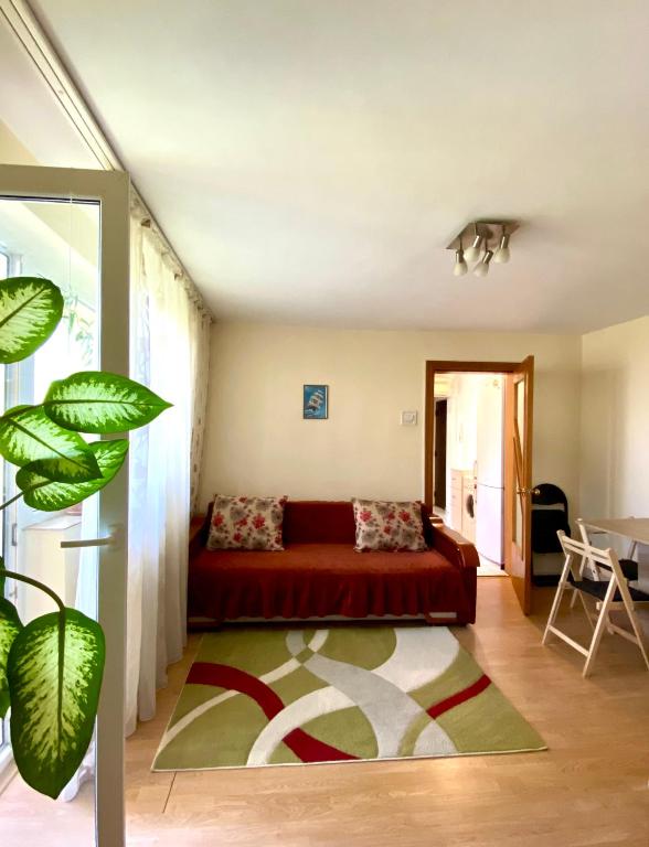 sala de estar con sofá rojo y mesa en Apartament Myria en Constanza