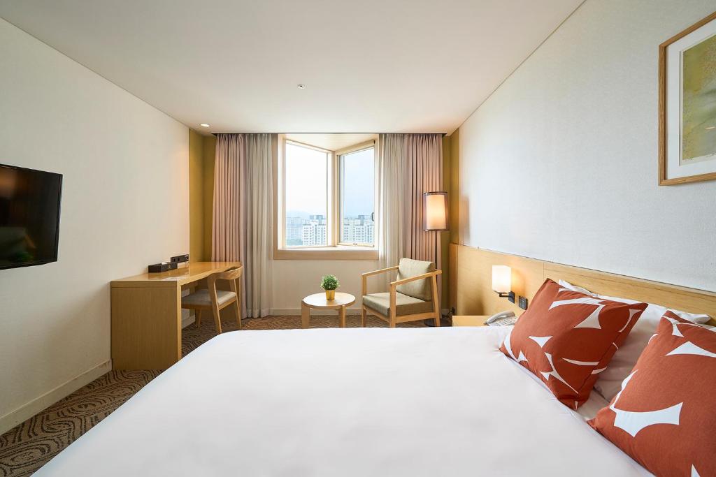 Un pat sau paturi într-o cameră la Jeju Central City Hotel
