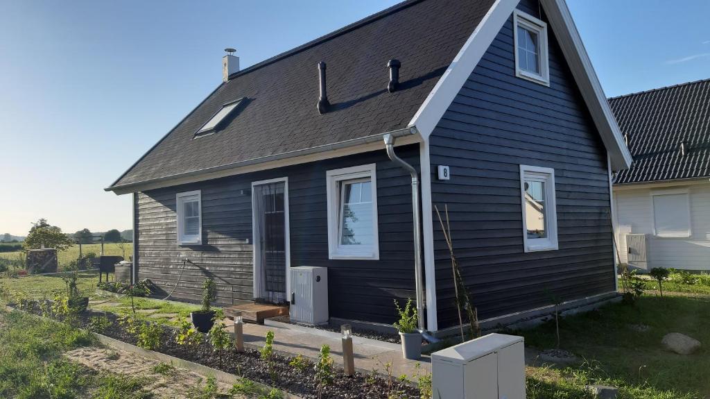 een zwart huis met een grijs dak bij Ferienhaus Lotte in Zerpenschleuse