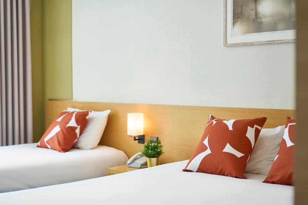Postel nebo postele na pokoji v ubytování Jeju Central City Hotel