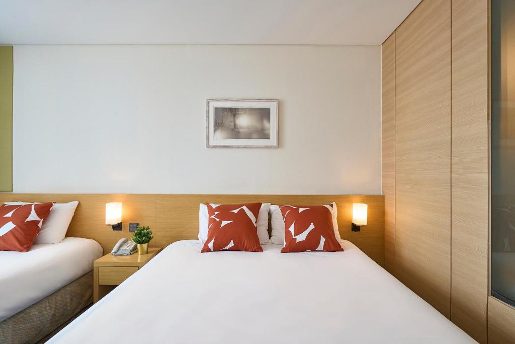 Postel nebo postele na pokoji v ubytování Jeju Central City Hotel