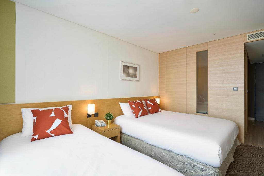 Postel nebo postele na pokoji v ubytování Jeju Central City Hotel