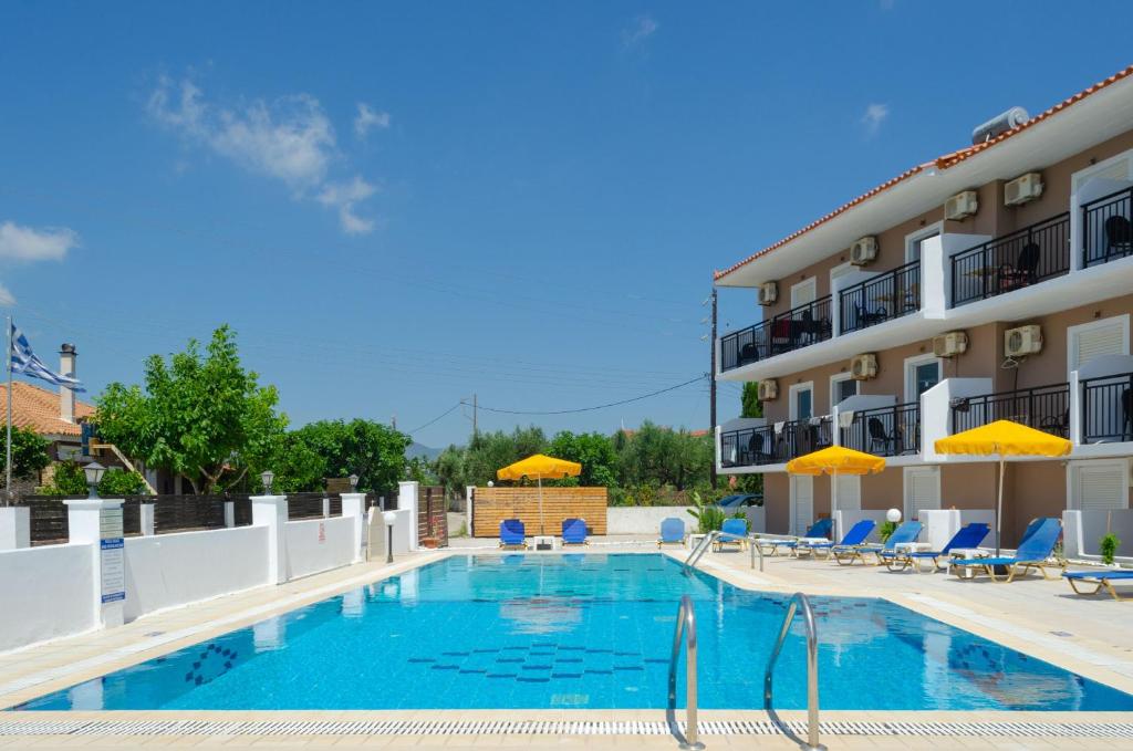 a pool at a hotel with chairs and umbrellas at Lecini Studios in Laganas