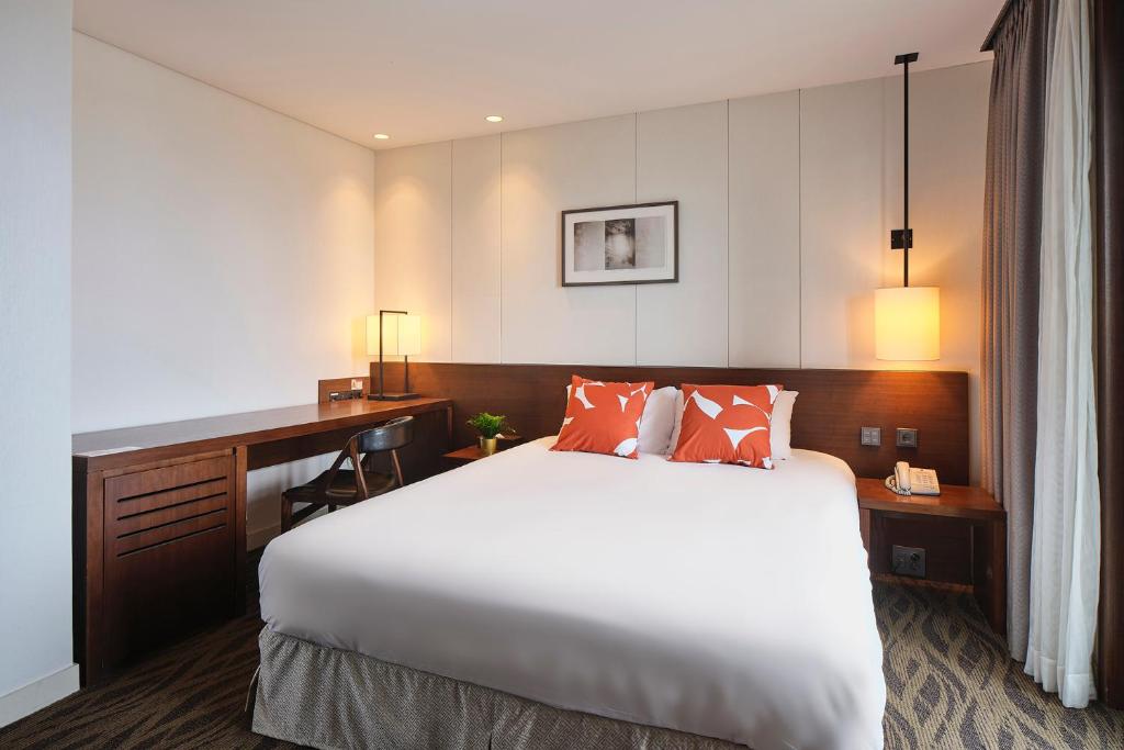 Postel nebo postele na pokoji v ubytování Jeju Central City Hotel
