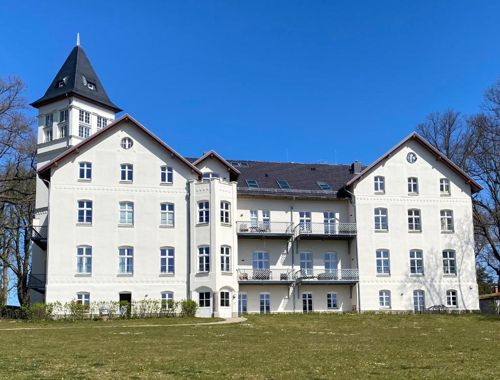 a large white building with a black roof at Jagdschloss Suite - premium castle hideway in Hohen Niendorf