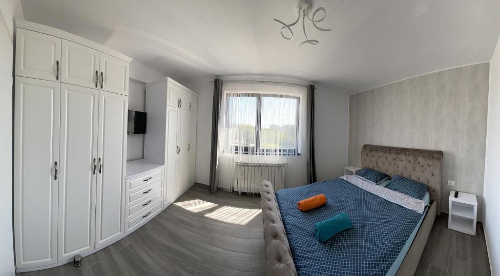 a bedroom with a blue bed and a window at LS Lake Apartment Mamaia Nord in Mamaia Sat/Năvodari